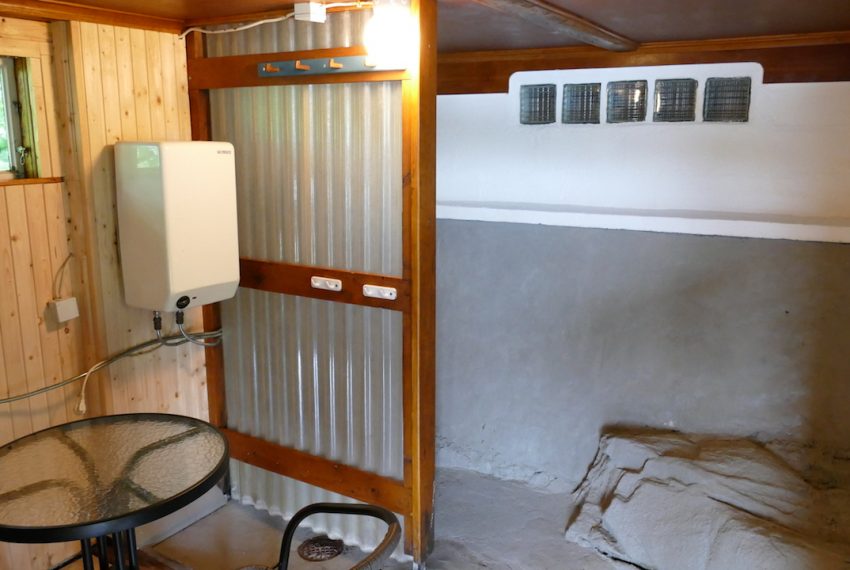 Saunavorraum mit Dusche und kleiner Sitzgelegenheit